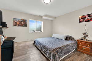 Bedroom with wood finished floors and a textured ceiling