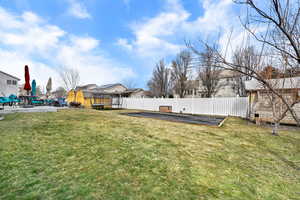 Fenced backyard with a patio area, a garden, and a residential view