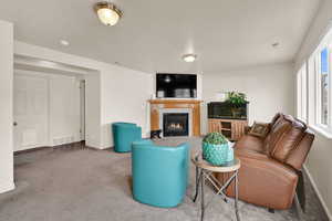 Carpeted living room featuring a fireplace and baseboards