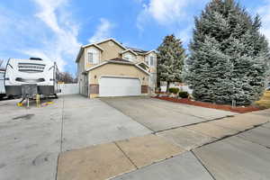 View of home's exterior with brick siding, roof mounted solar panels, a gate, stucco siding, and concrete driveway