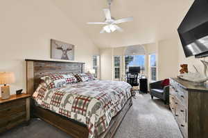 Bedroom with carpet, ceiling fan, vaulted ceiling, and a desk