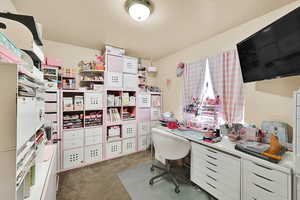 Office area featuring light carpet and a textured ceiling