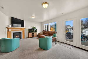 Carpeted living area featuring a tiled fireplace