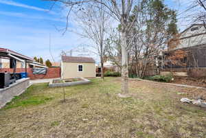 Fenced backyard with a vegetable garden and a storage shed