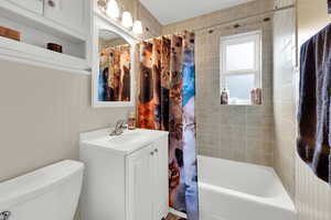 Full bath featuring shower / bathtub combination with curtain and vanity