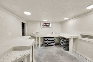 Bar featuring a textured wall, a textured ceiling, and concrete floors