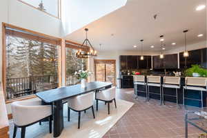 Dining area featuring light tile patterned flooring and suspended lighting