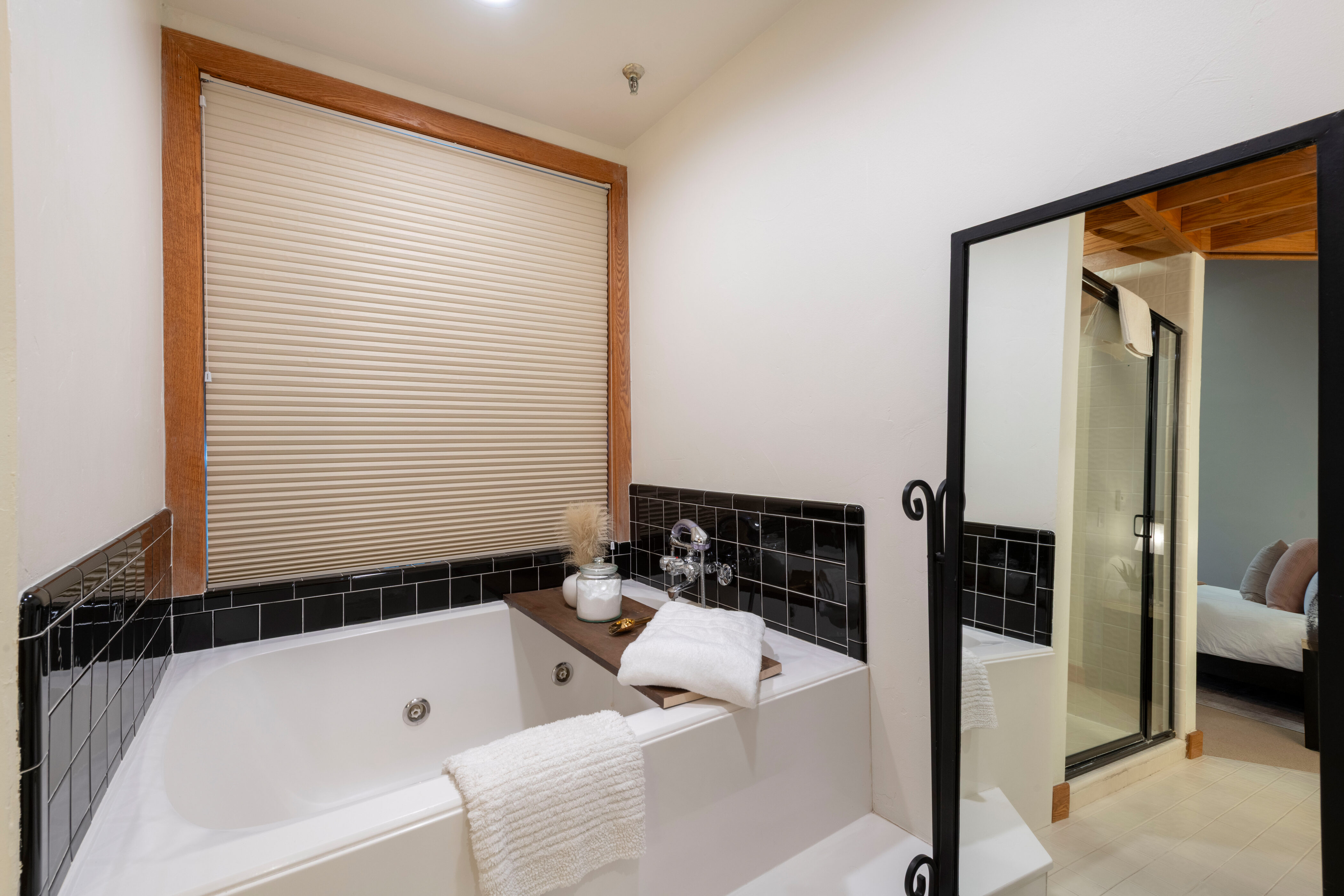 Ensuite bathroom featuring a whirlpool tub and a stall shower
