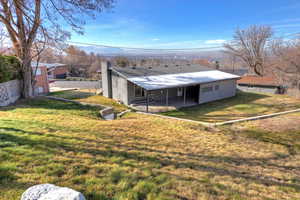 Rear view of house with a chimney and a patio