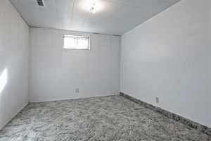 Carpeted spare room featuring baseboards