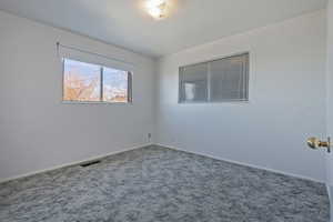 Carpeted spare room with baseboards