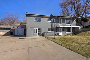 View of front of property featuring a storage shed, brick siding, and a balcony