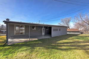 Rear view of property featuring a yard and a patio area