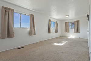 Carpeted empty room featuring healthy amount of natural light
