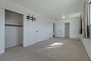 Unfurnished bedroom featuring two closets and light colored carpet