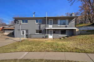 Rear view of property with a chimney and brick siding