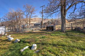 Fenced yard featuring a mountain view and an outbuilding