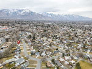 Aerial view of property and surrounding area featuring nearby suburban area and a mountain backdrop