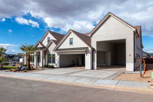 View of front of property featuring concrete driveway and a standing seam roof