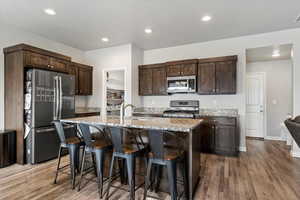 Chef-ready kitchen includes granite countertops, beautifully stained cabinetry, stainless steel appliances, a gas range, and a large pantry.