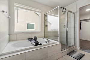 Ensuite bathroom, double vanity, tile flooring, full tile shower, separate soaking tub, and a large walk-in closet