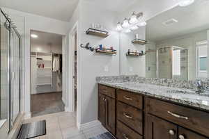Ensuite bathroom, double vanity, tile flooring, full tile shower, separate soaking tub, and a large walk-in closet