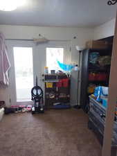 Bedroom featuring dark colored carpet, multiple windows, and a textured ceiling