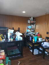 Office area featuring dark wood-type flooring, recessed lighting, and wood walls