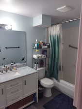 Full bath with vanity, shower / bath combo, and dark wood-type flooring