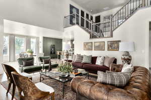 Living room featuring a high ceiling and wood finished floors