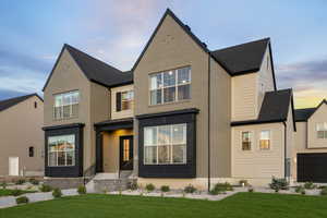 View of front facade with a front lawn, brick siding, and a shingled roof