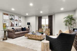 Living area with light wood-style floors and recessed lighting