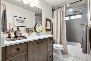 Full bath with shower / bath combination with curtain, vanity, and a textured ceiling