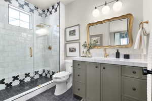 Full bathroom featuring plenty of natural light, vanity, a shower stall, and dark tile patterned flooring