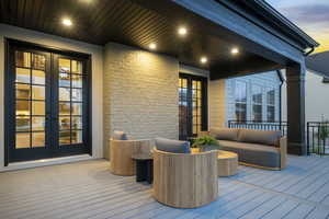 Deck at dusk with french doors and outdoor lounge area