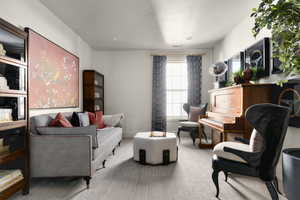 Sitting room featuring carpet and a textured ceiling