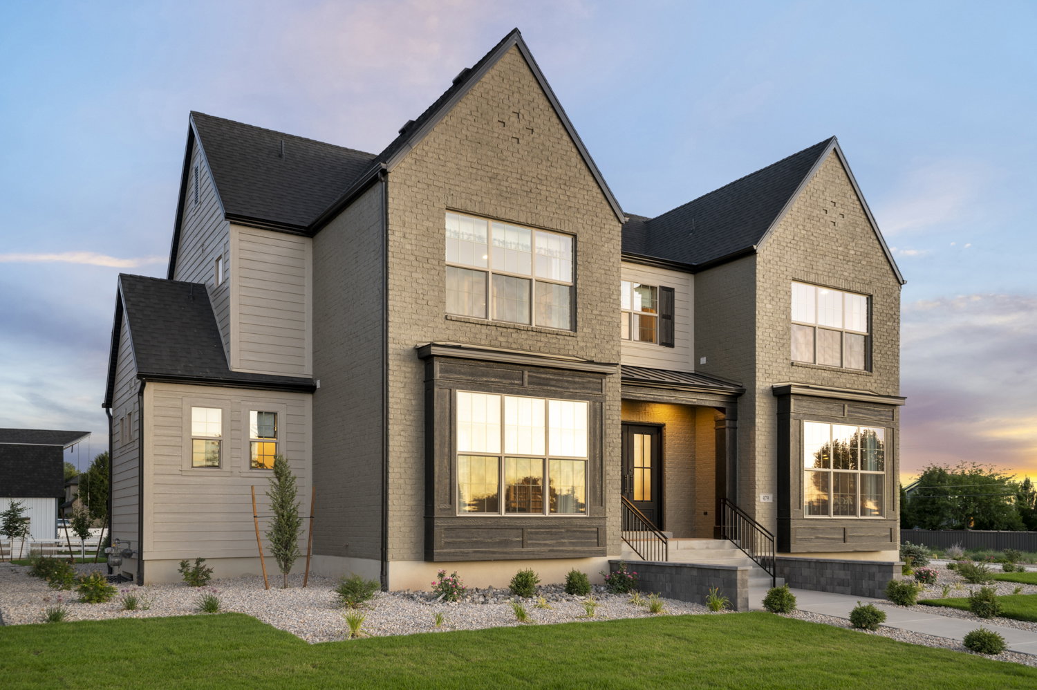 View of front of property featuring brick siding, a front yard, and a standing seam roof