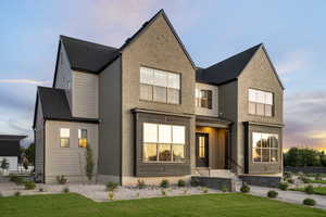 View of front of property featuring brick siding, a front yard, and a standing seam roof