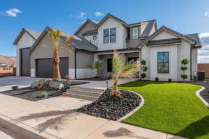 Modern inspired farmhouse with driveway, a garage, board and batten siding, and a front yard
