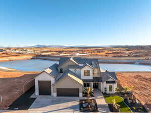 Modern farmhouse featuring a mountain view, a garage, concrete driveway, a standing seam roof, and roof with shingles