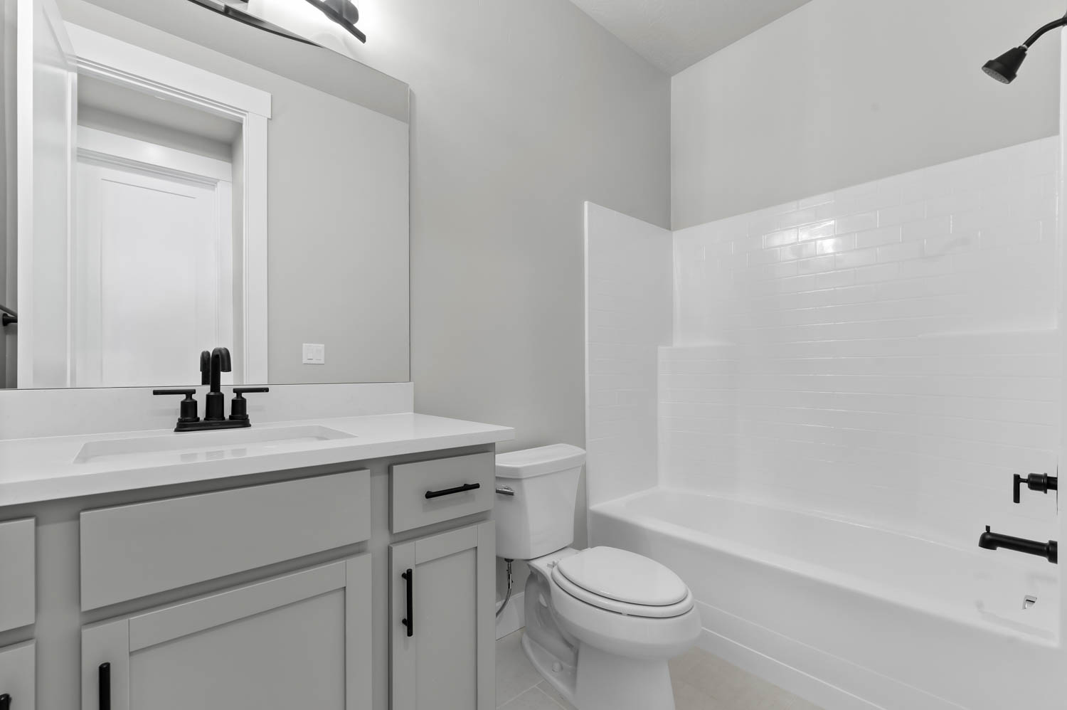 Bathroom featuring vanity, shower / bathtub combination, and light tile patterned flooring