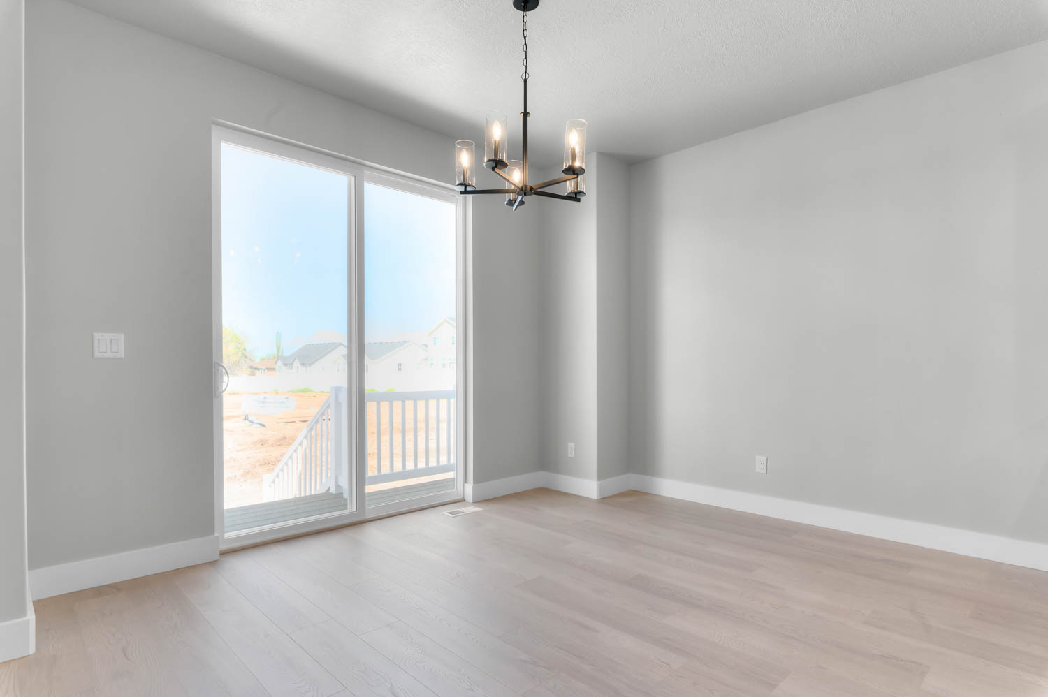 Spare room with hanging lights and light wood finished floors