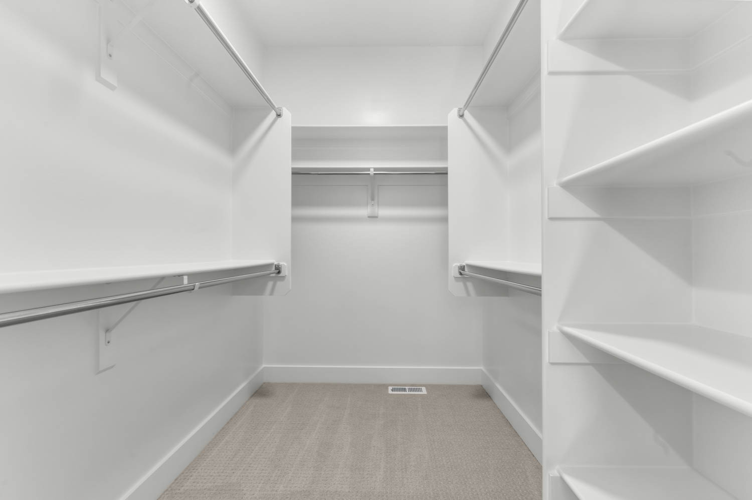 Walk in closet featuring light colored carpet
