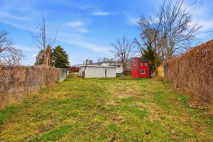 Fenced backyard featuring a storage shed