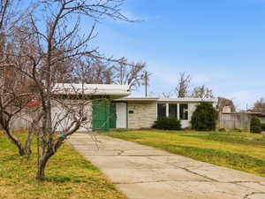 View of front of home featuring driveway, a residential view, and a front yard
