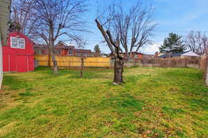 Fenced backyard featuring a storage shed and a residential view