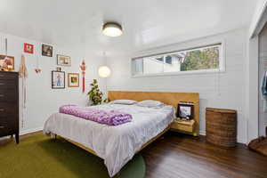 Bedroom featuring wood finished floors and brick wall