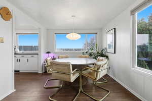 Dining area featuring dark wood-style floors and wood walls