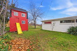 View of grassy yard with an outbuilding