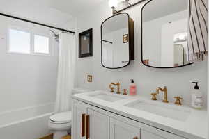 Bathroom with double vanity and shower / tub combo